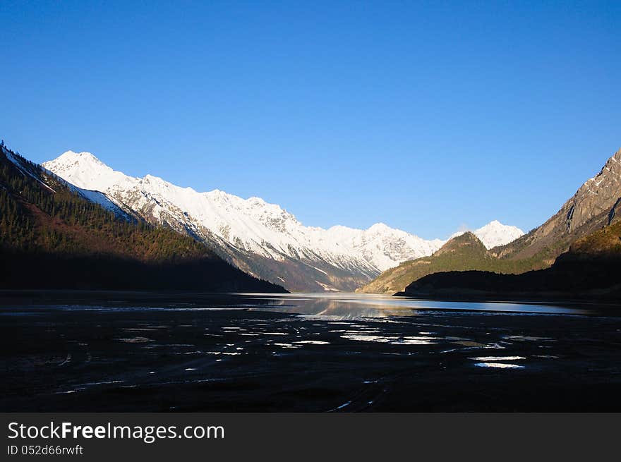 Snow-capped mountains next to the lake. Snow-capped mountains next to the lake