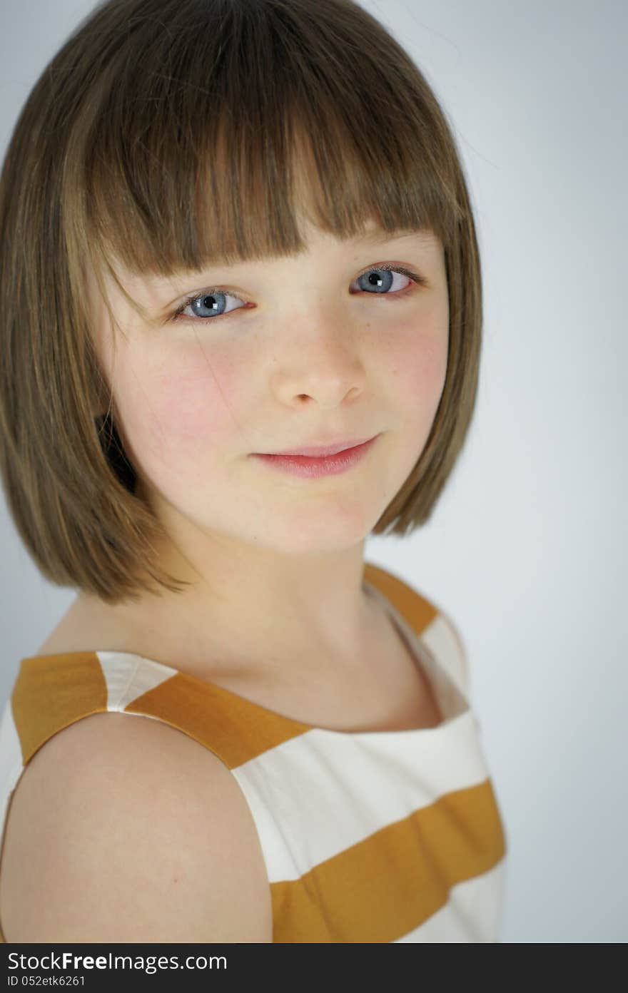 A simple portrait of a young girl with a slight smile. A simple portrait of a young girl with a slight smile.