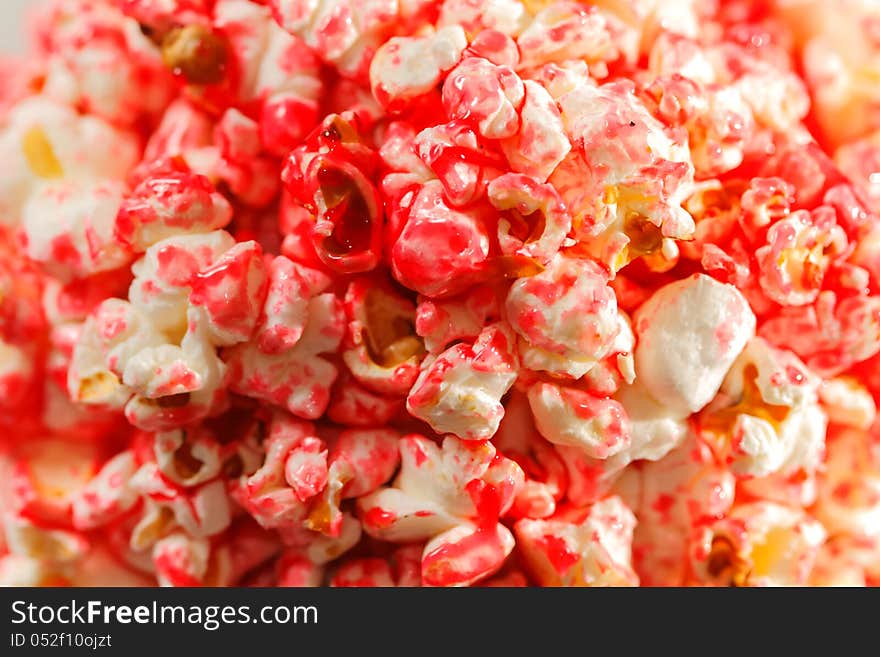 Sweet popcorn with pink sugar syrup background. Selective focus.