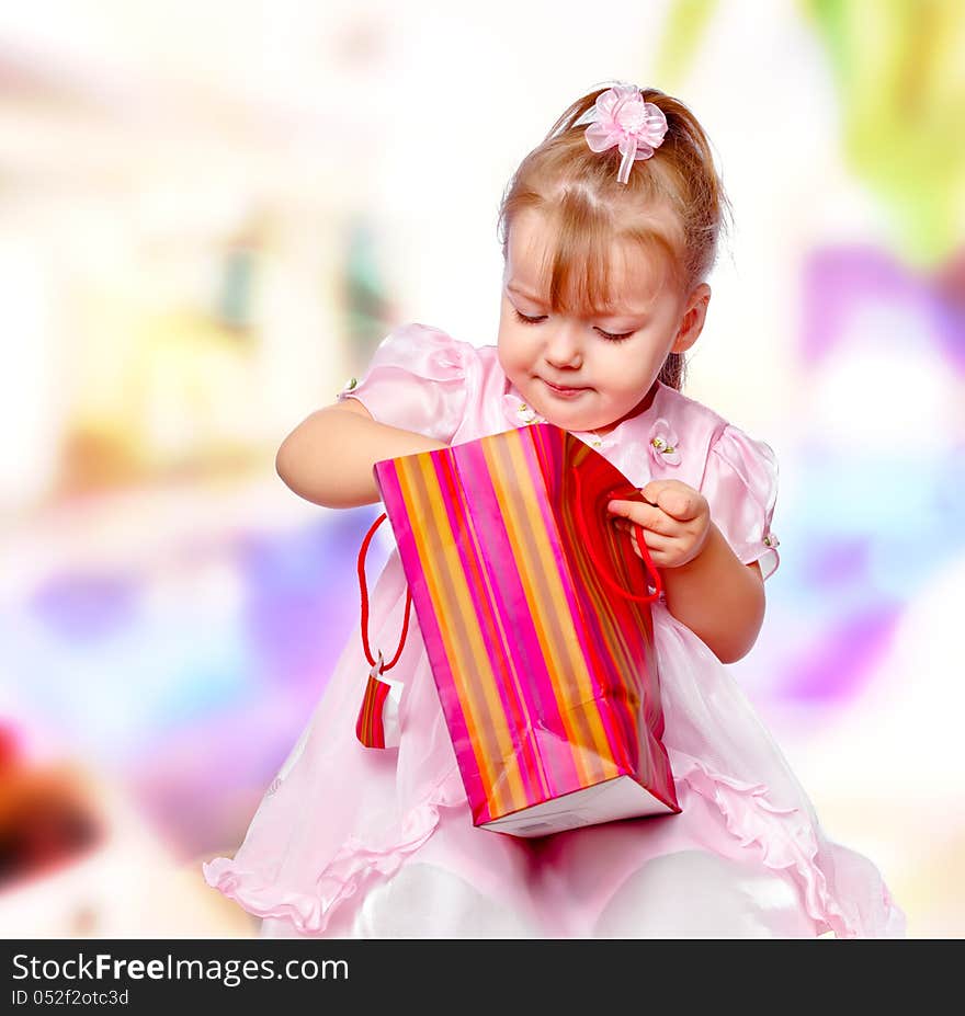 Portrait of the girl in the mall holding a gift