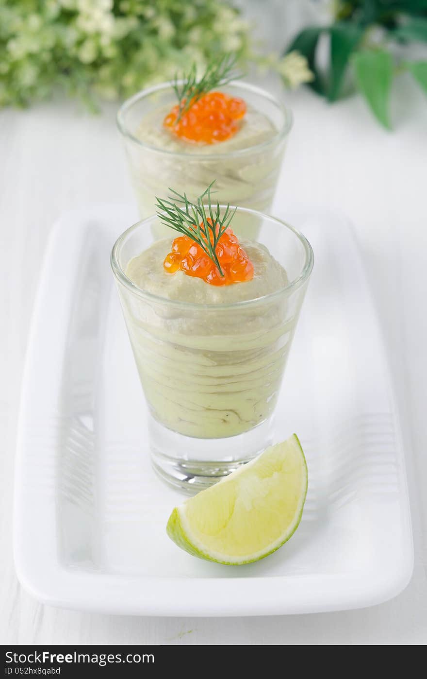 Avocado cream and red caviar in glasses. Avocado cream and red caviar in glasses