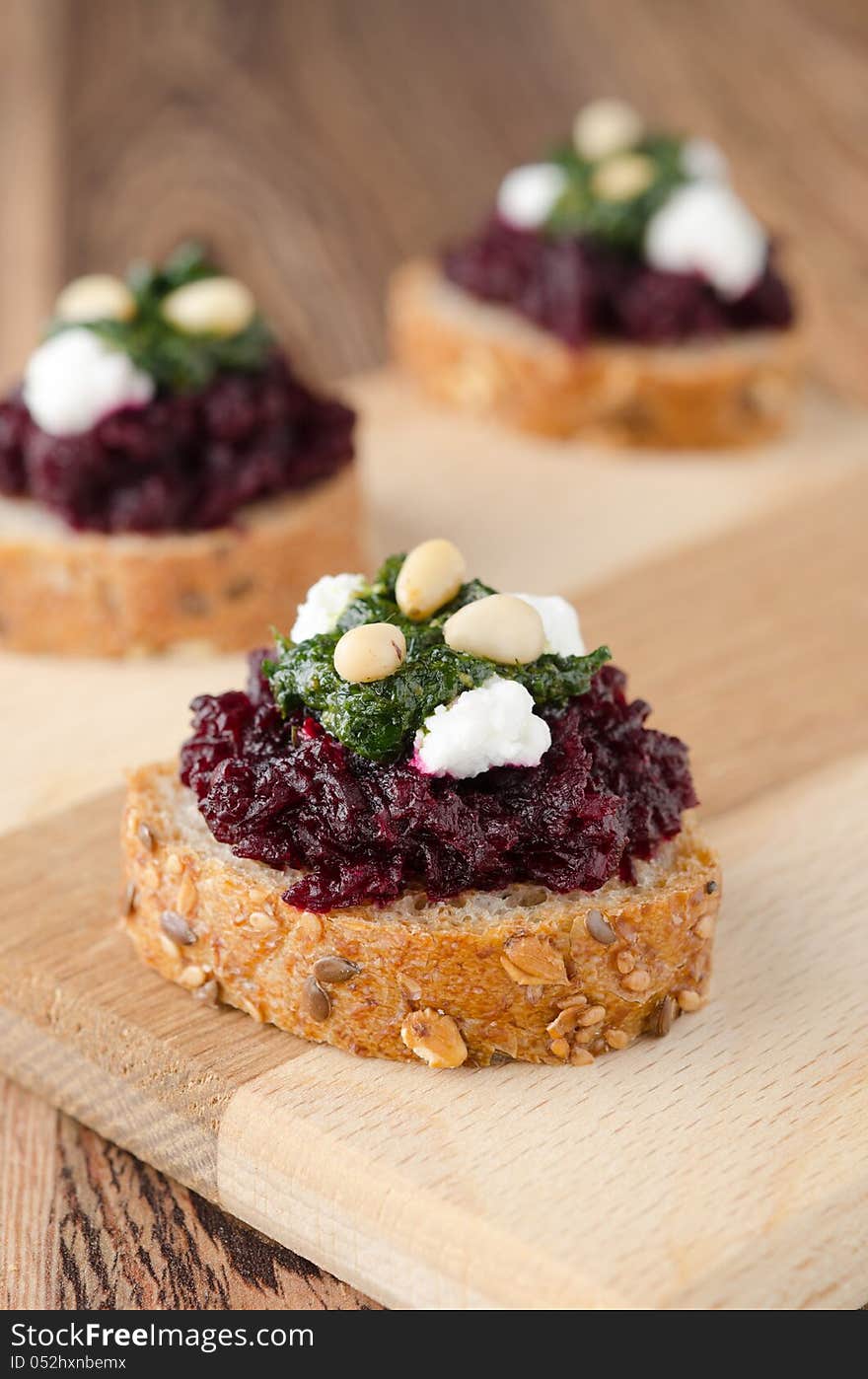 Beet salad with pesto and goat cheese on toasted grain breads on