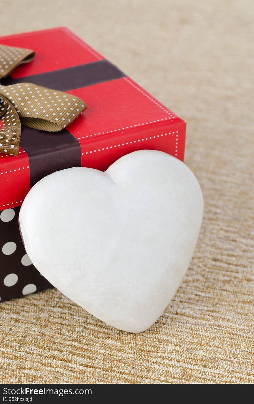 Cookie with icing in the form of heart near the gift box, select