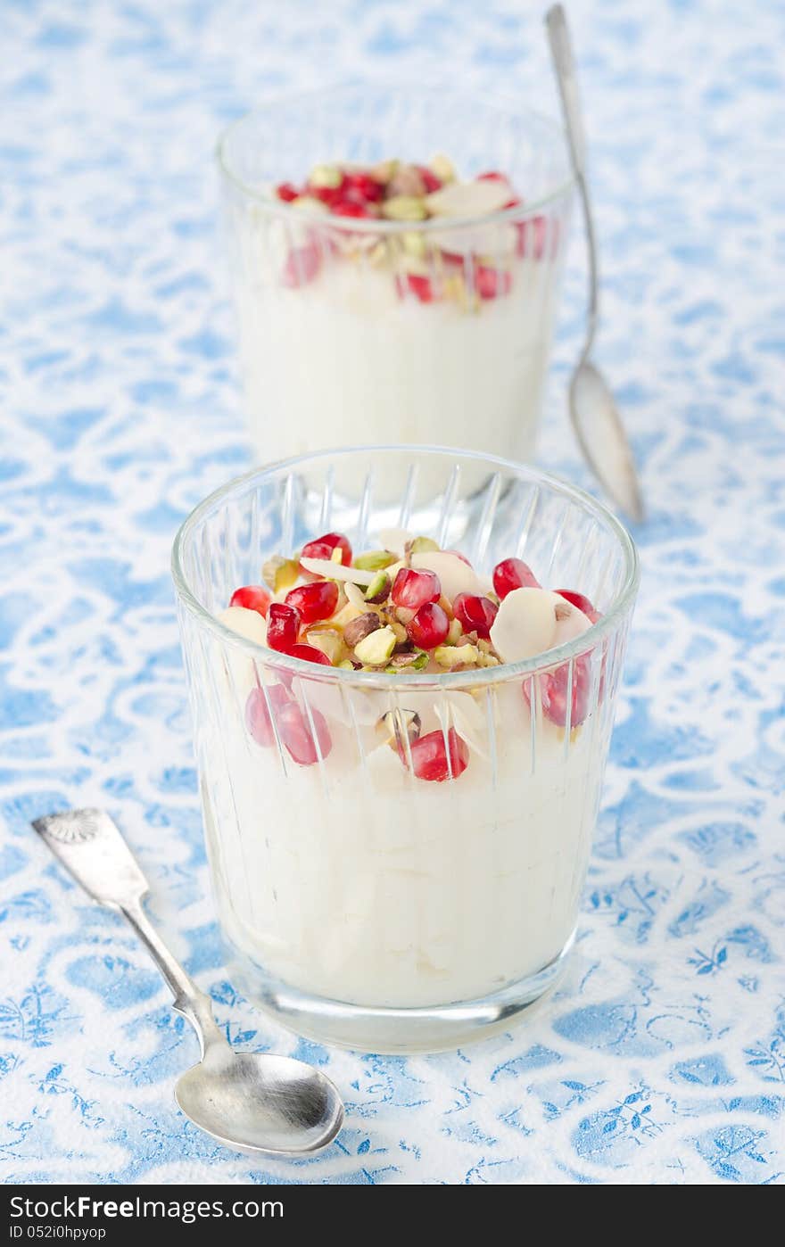 Semolina dessert with pomegranate seeds and pistachios in a glas