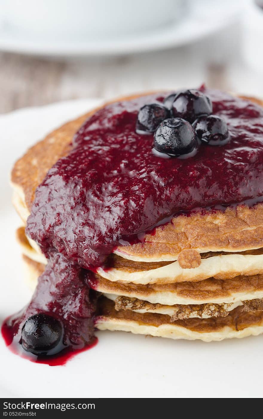 Stack of pancakes with black currant jam on a plate closeup. Stack of pancakes with black currant jam on a plate closeup