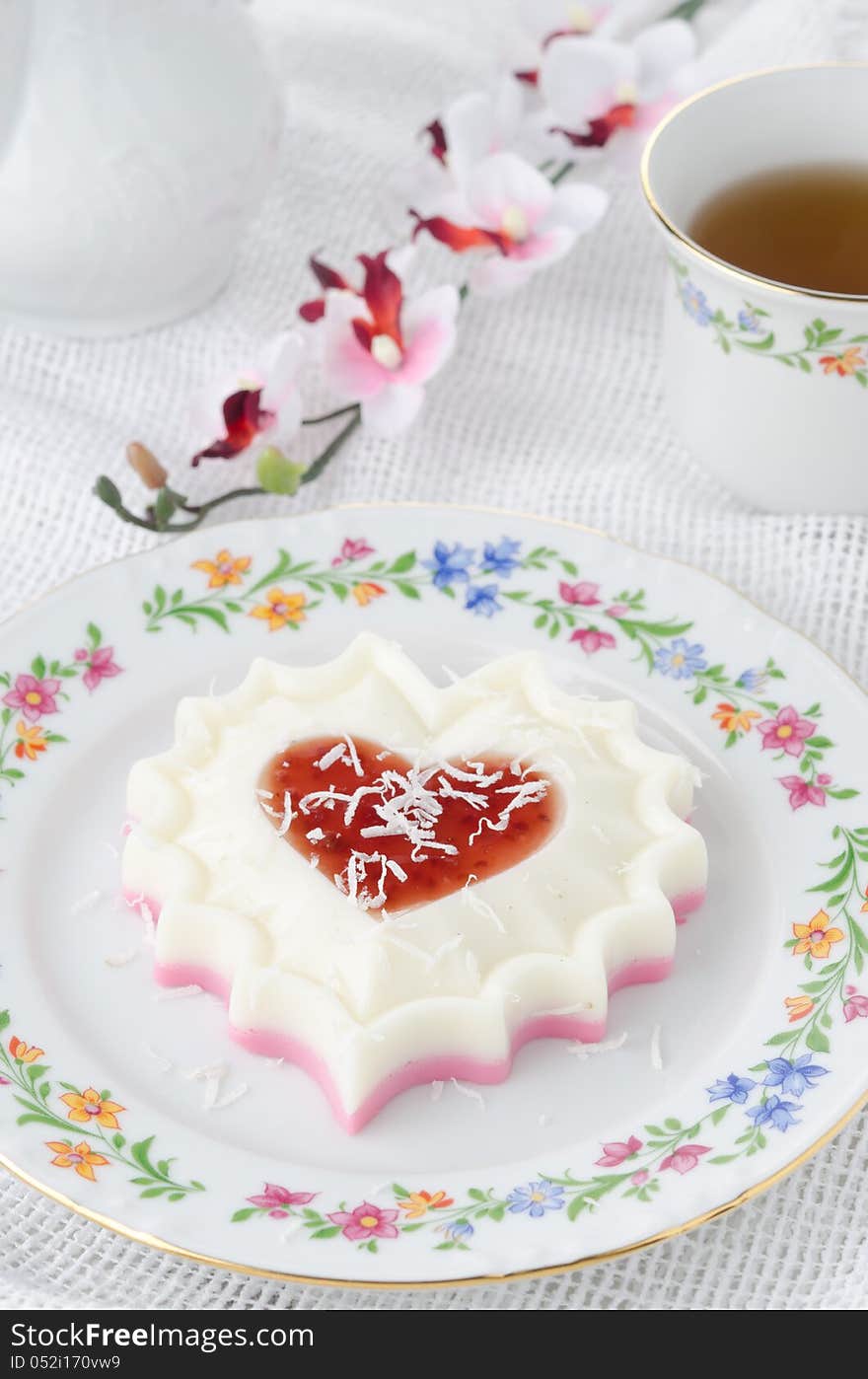 Two-layer dessert of cream and jam and coconut on white plate