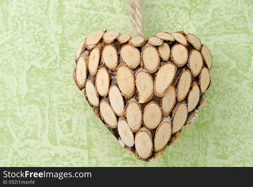 Wooden heart closeup on a green background