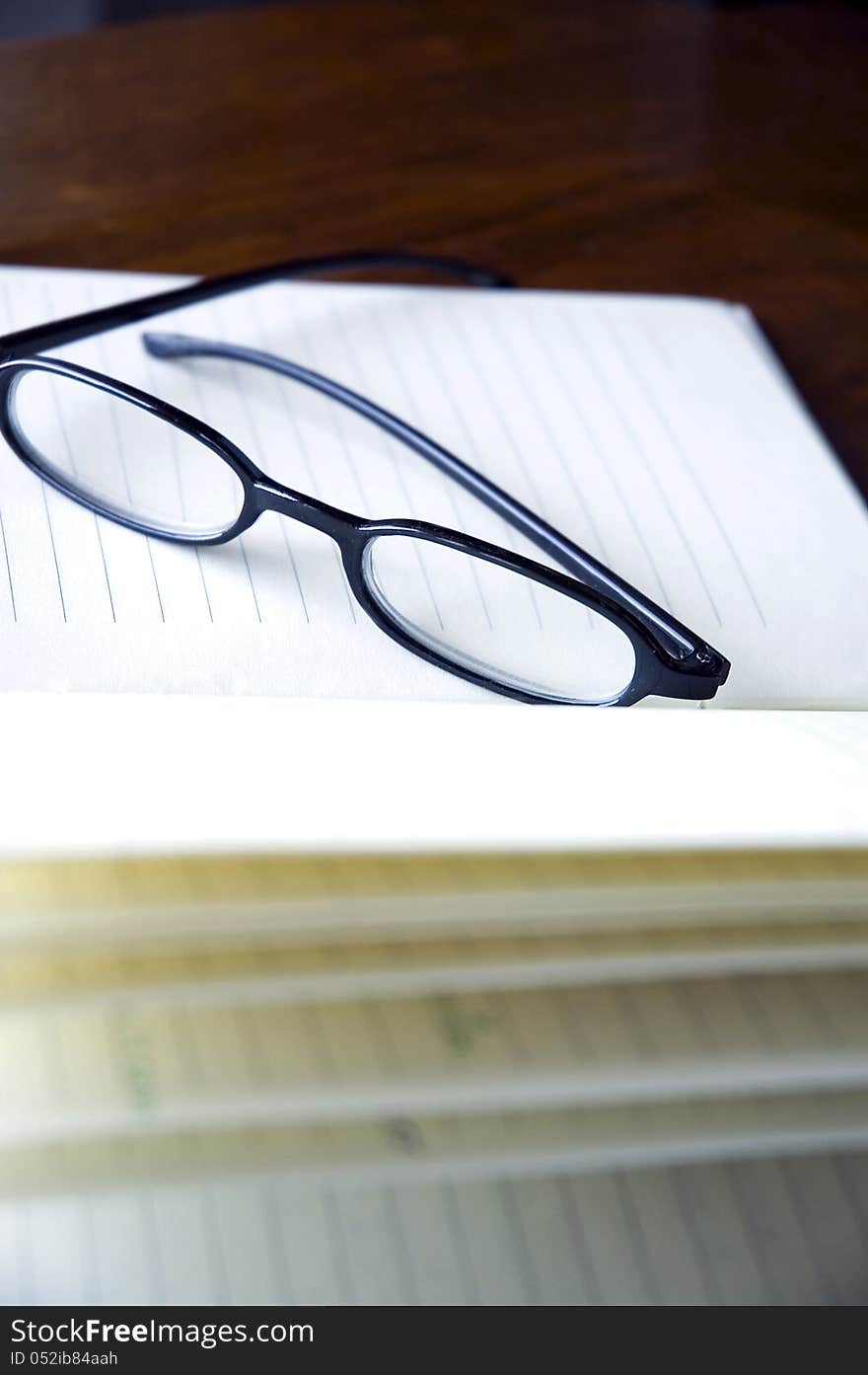 Black frame eyeglasses put on notebook