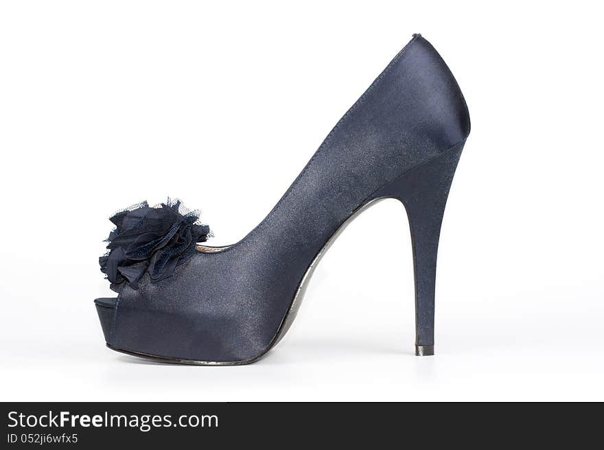 Stylish satin-finish ladies stiletto shoe in dark blue with an open toe and a floral decoration for classical formal wear on a white studio background