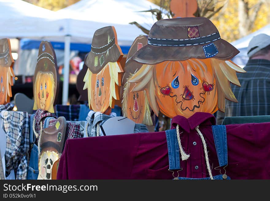 Colorful wooden scarecrow stands on display.