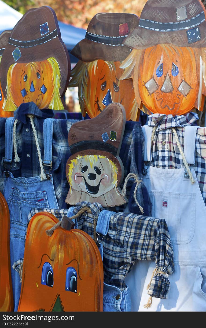 Colorful wooden scarecrow stands on display.