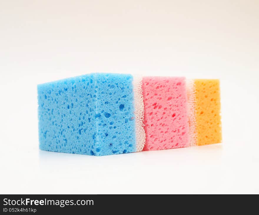 Pink, blue and orange sponge, towards white background