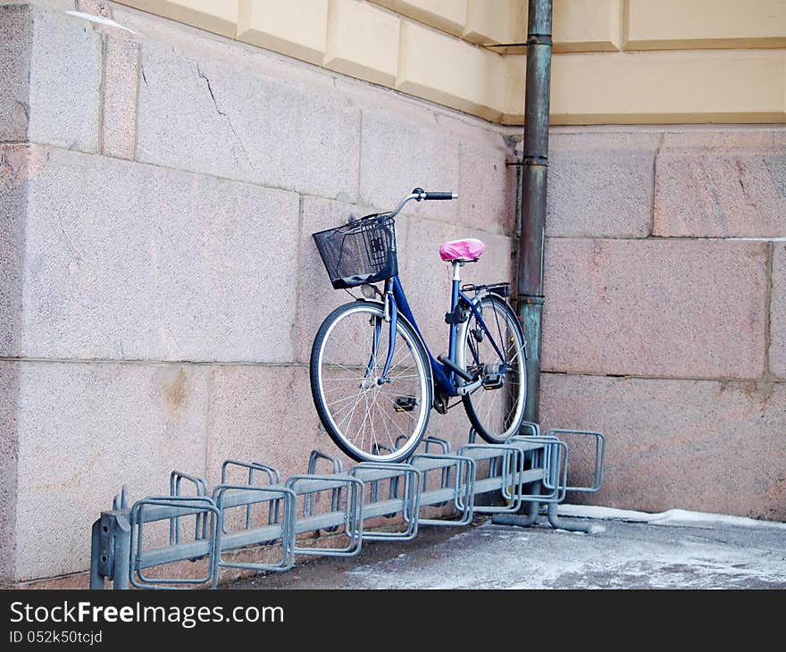 Bike left above a bike rack, towards a stone brick building