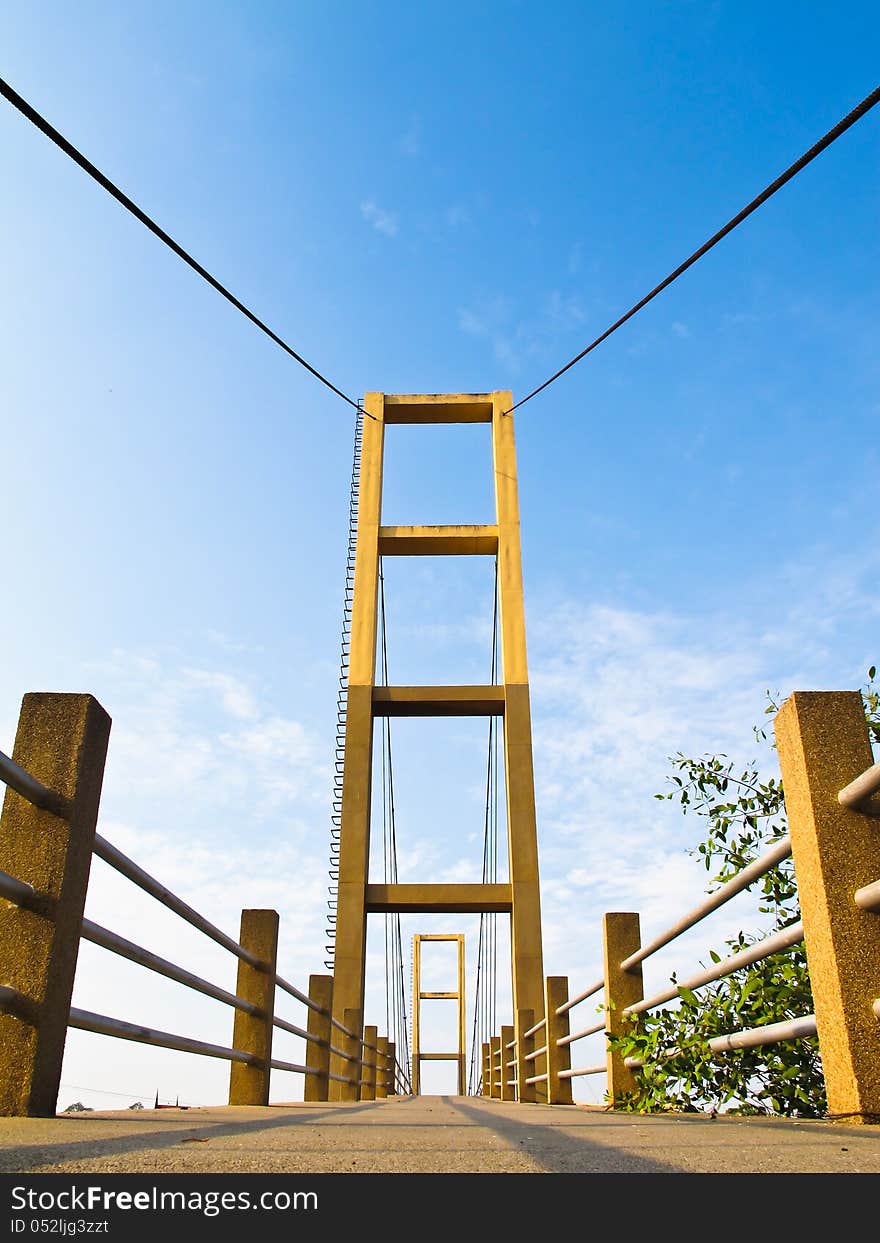 Cable bridge pole with concrete way and blue sky background