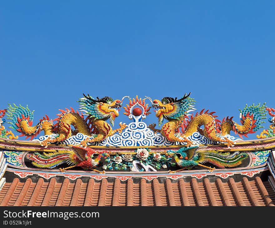 Twin Chinese dragon on the temple roof with blue sky background