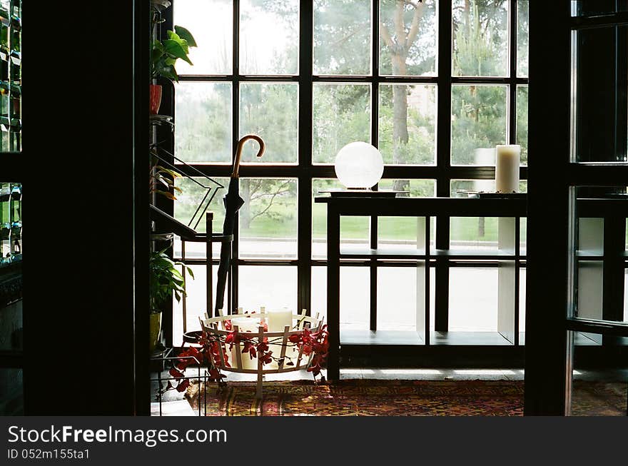 Wide window with candle, umbrella, carpet and black furniture in modern living room. Wide window with candle, umbrella, carpet and black furniture in modern living room