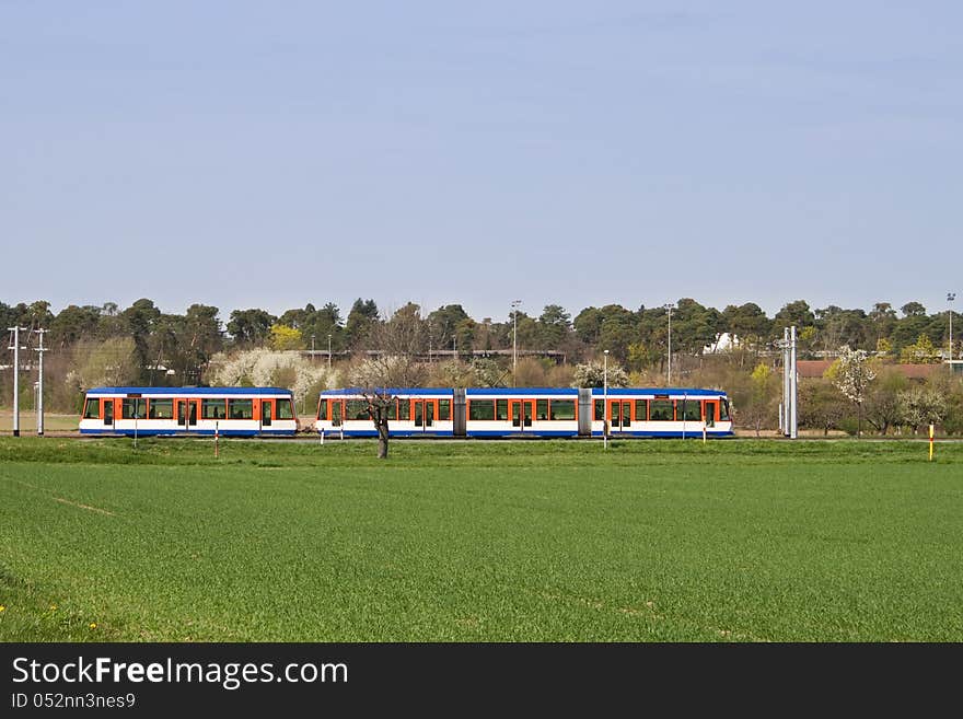 Tram driving through rural landscape