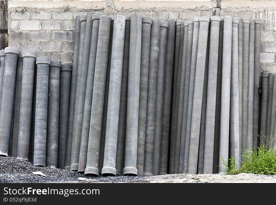 Stack of many concrete drainage pipe on wall in construction site