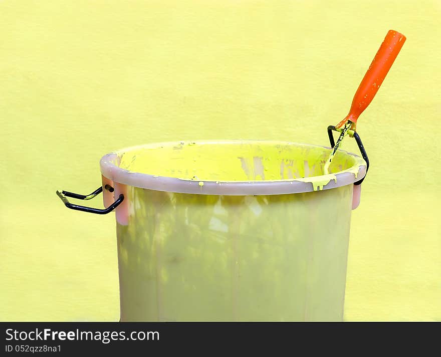 Paint-roller and Paint bucket with paint on a green background