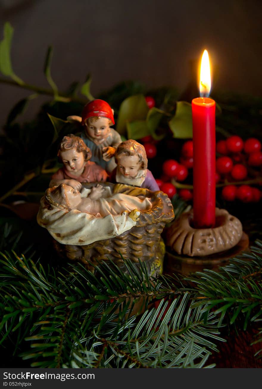 Close-up of the Child Jesus with the candle between the leaves of the Christmas tree. Close-up of the Child Jesus with the candle between the leaves of the Christmas tree