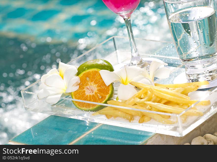 French-fries and orange in snack tray by the pool