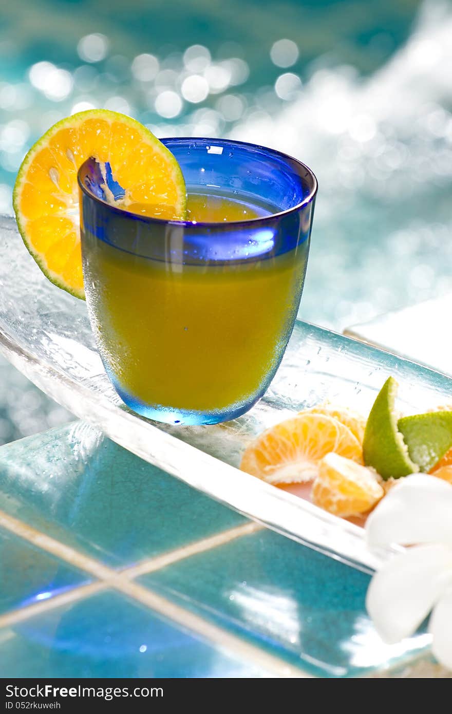 Orange juice decorated with orange in blue glass