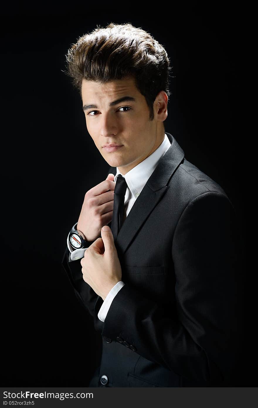 Portrait of a young businessman, isolated on black background