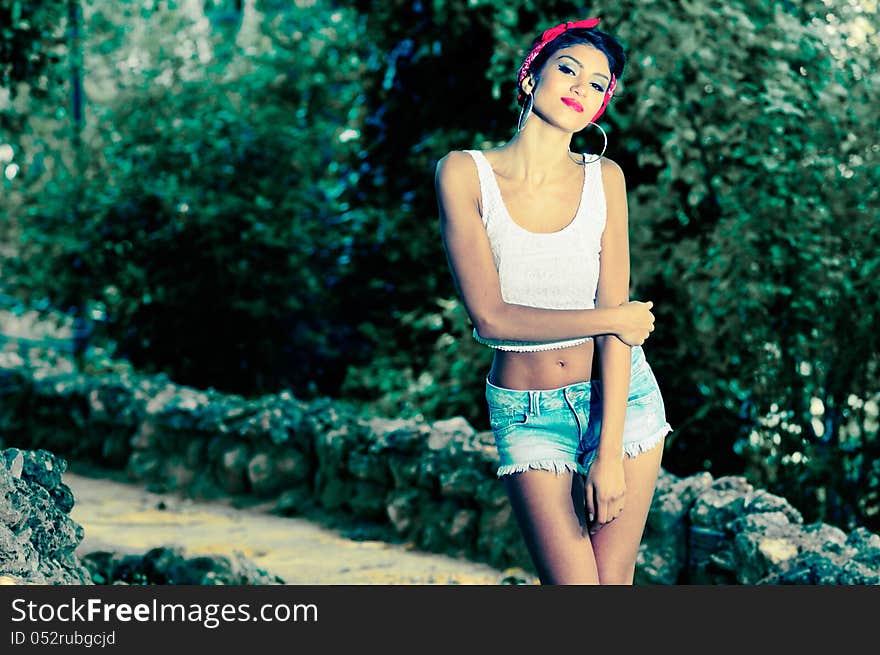 Portrait of a pin-up girl. American style, in a garden, wearing jeans and t-shirt