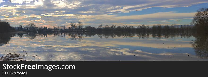 Panoramic view of sky, clouds and darkness reflecting in the  river. Panoramic view of sky, clouds and darkness reflecting in the  river