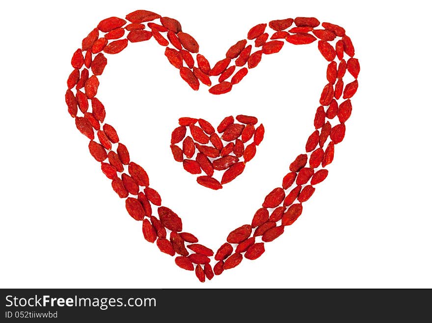 Red dried Goji berries in the shape of heart isolated on white background. Red dried Goji berries in the shape of heart isolated on white background