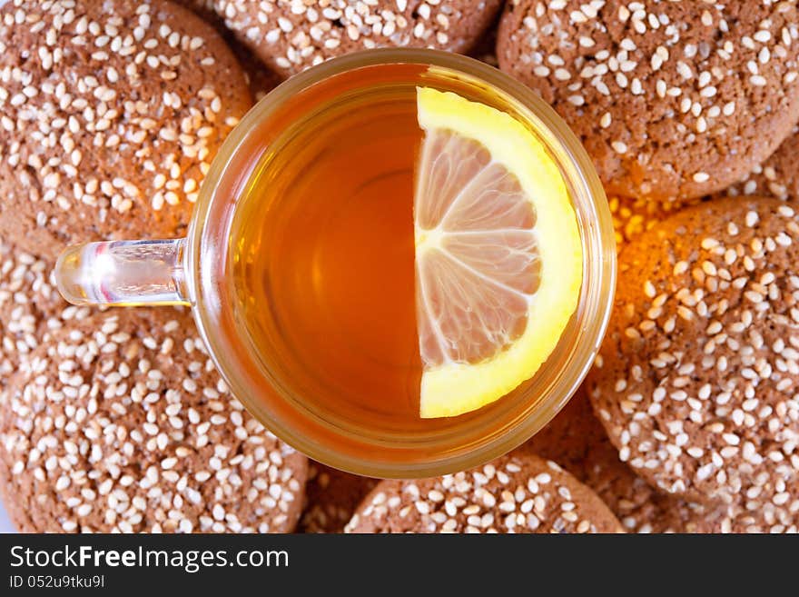 Cup of tea with lemon on a background of cookies