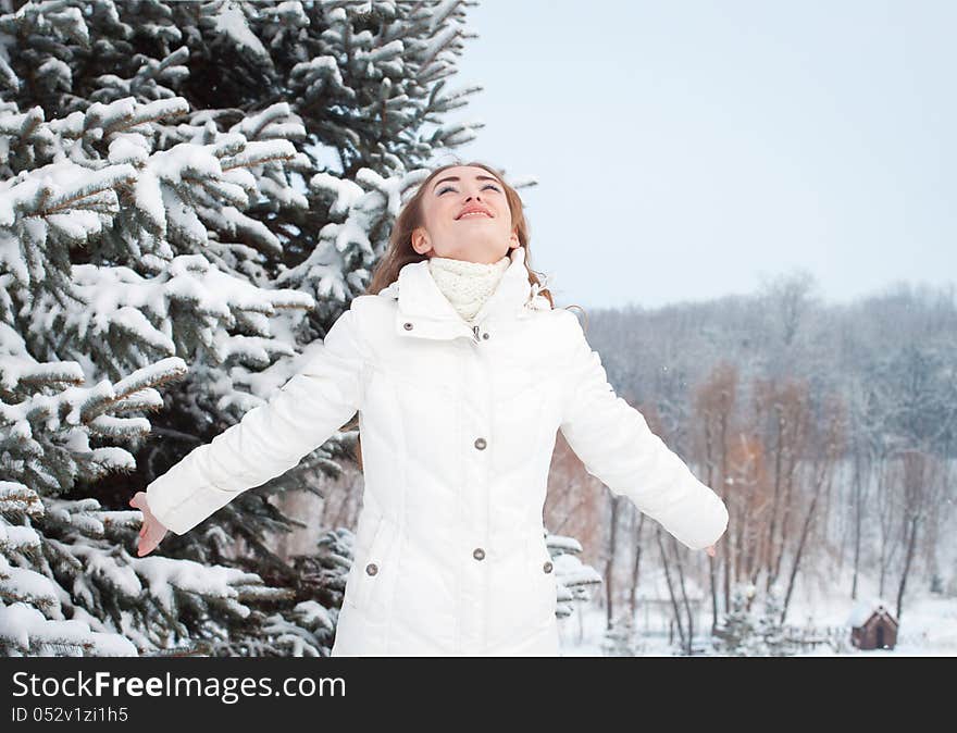 Smiling Woman With Arms Raised To The Sky On A Winter Day