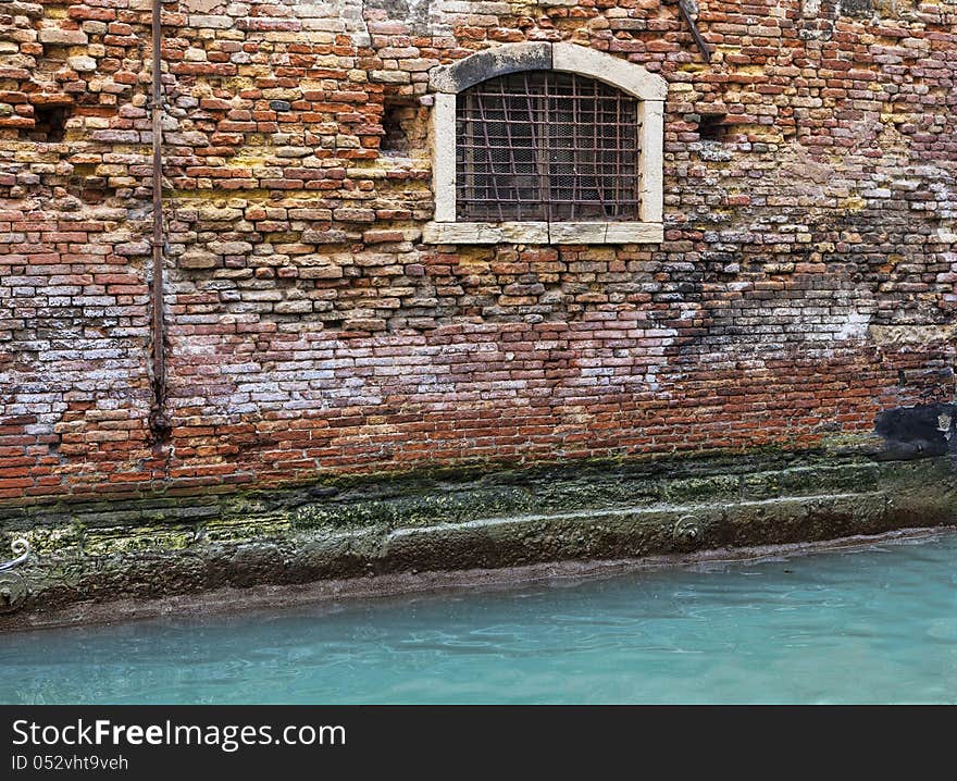 Detail of a brick wall of a Venetian house near a specific canal. Detail of a brick wall of a Venetian house near a specific canal.