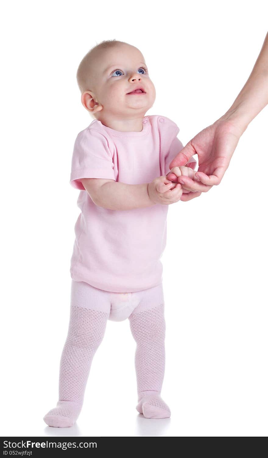 Cute baby learning to walk by holding his mother's hands