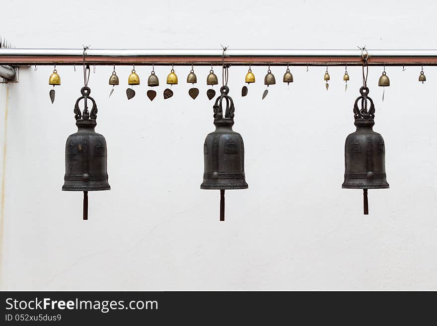 Three bells hanging on pillars at white wall. Three bells hanging on pillars at white wall.