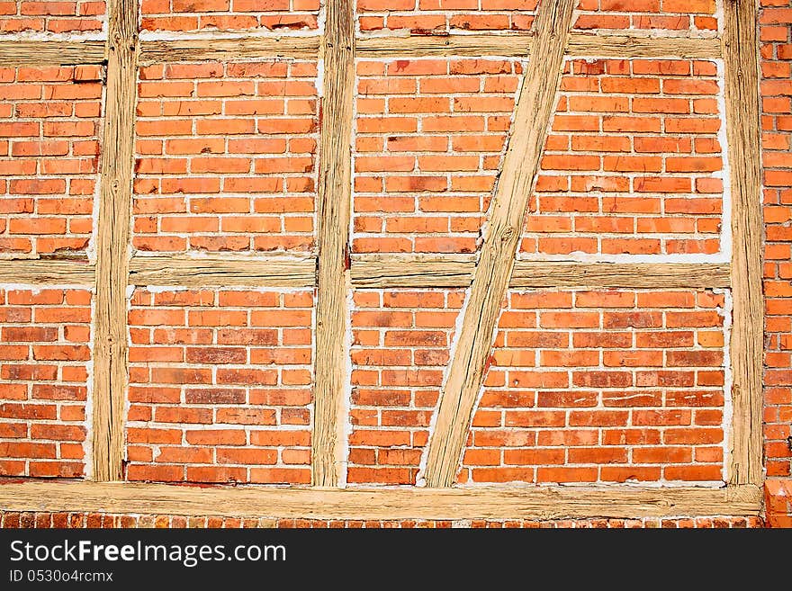 Old red brick wall with wooden beams as background