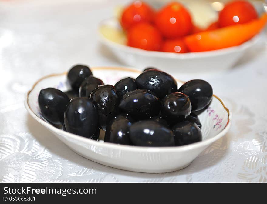 Plate with delicious big black olives served on the table. Plate with delicious big black olives served on the table