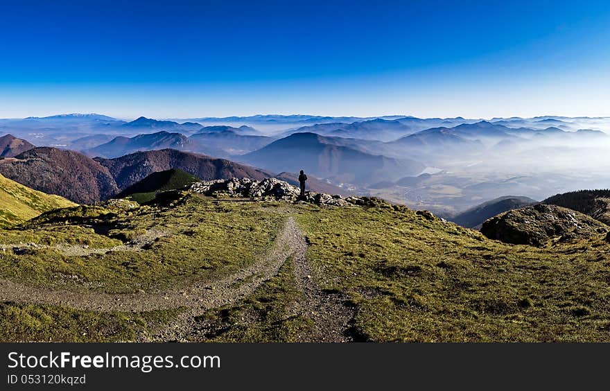 Silhouette of a man overlooking misty mountains landscape in Mala Fatra, Slovakia