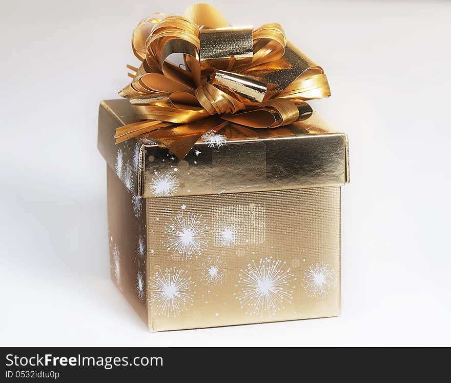 Gift packed into a gilded foil and decorated with a bow