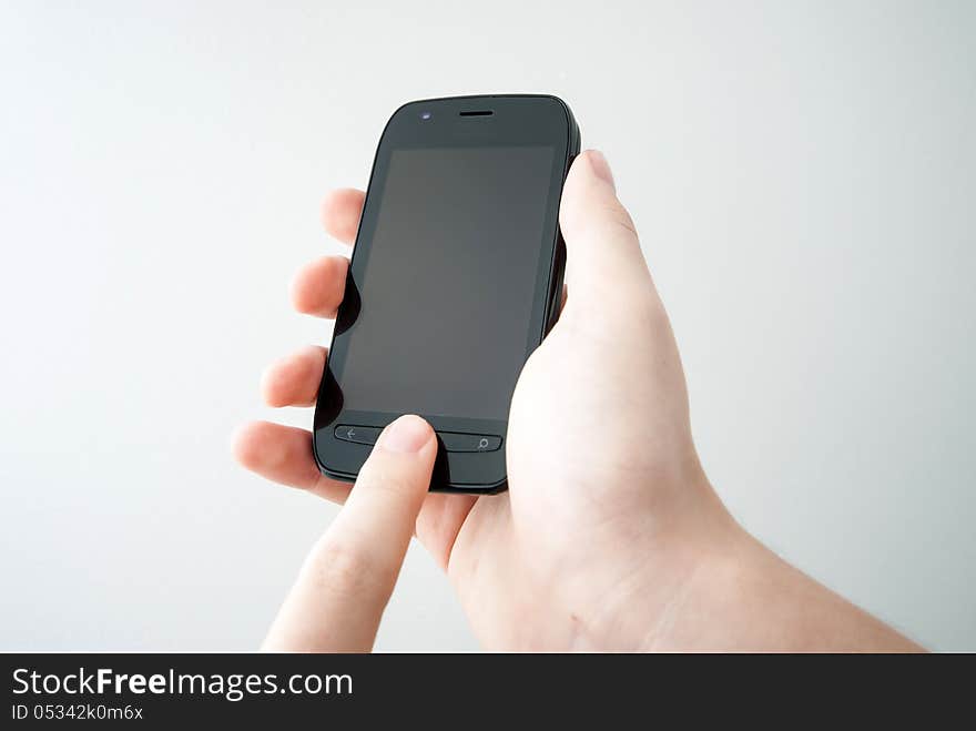 Hand holding mobile black smart phone on white background. Hand holding mobile black smart phone on white background