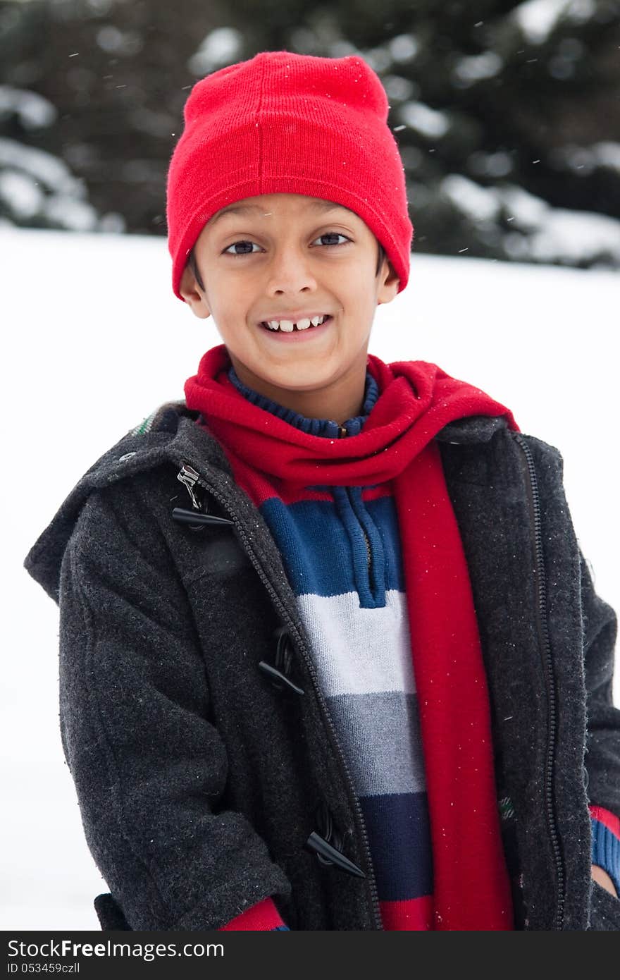 Happy East Indian boy playing in the snow