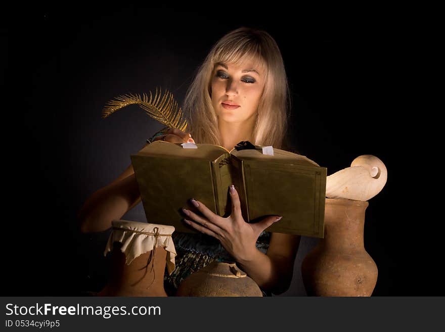Portrait of blonde girl on a dark background in the hands of a book. Portrait of blonde girl on a dark background in the hands of a book.