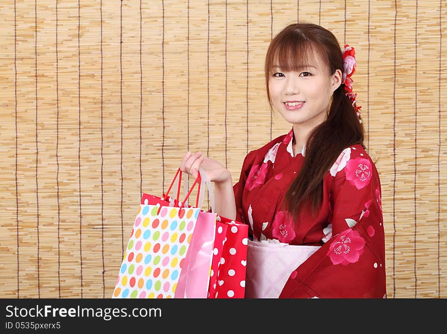 Young asian woman in traditional clothes of kimono with shopping bags. Young asian woman in traditional clothes of kimono with shopping bags