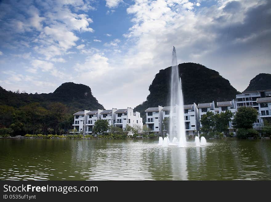 Fountain in lake of modern house with blue sky and cloud