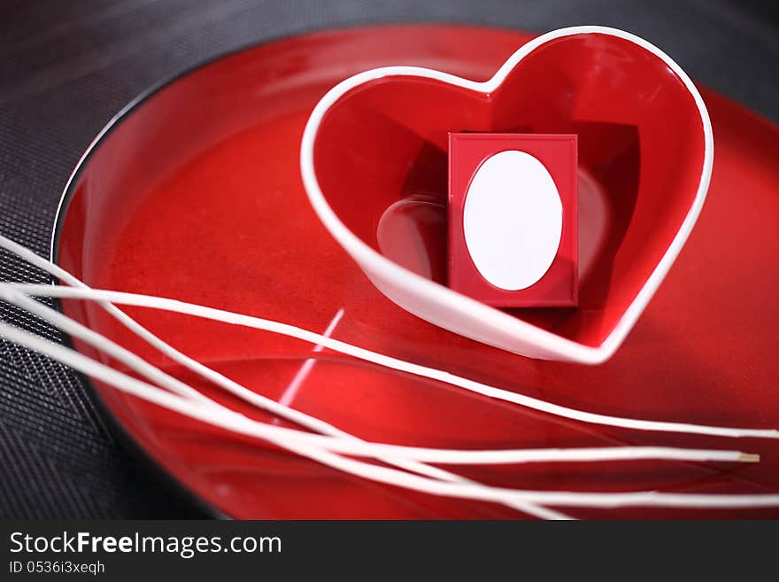 Red glass heart on a plate. Photo Frame inside heart. Red glass heart on a plate. Photo Frame inside heart