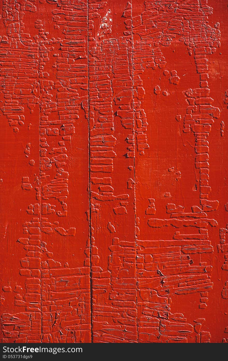 An old wood door panel with cracked red paint and grunge. An old wood door panel with cracked red paint and grunge