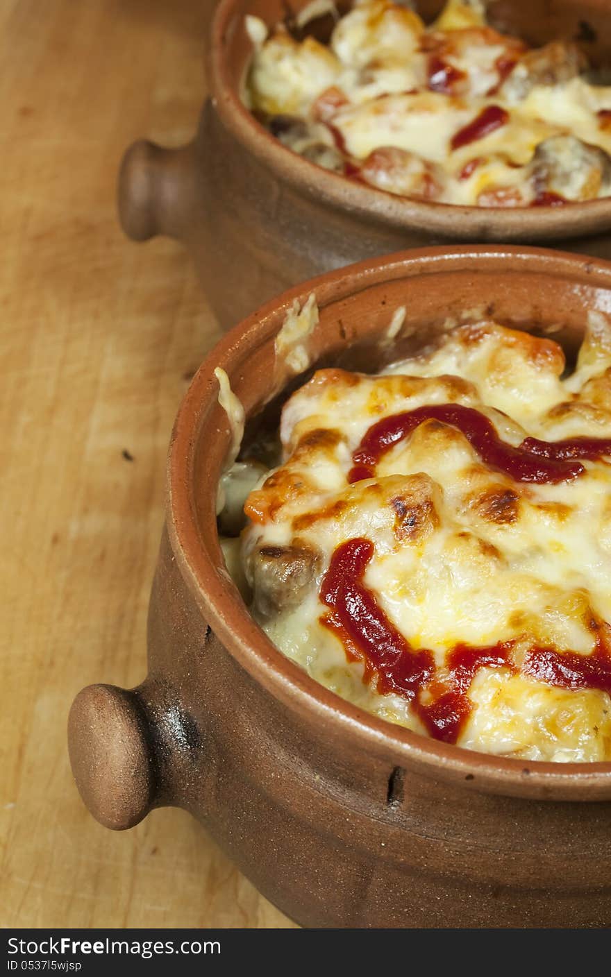 Homemade meat and vegetable stew with cheese and ketchup in pots. Homemade meat and vegetable stew with cheese and ketchup in pots