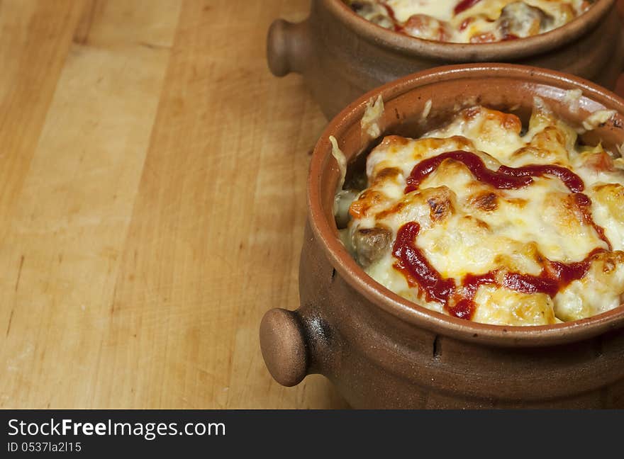 Meat and vegetables with cheese and ketchup  in pots