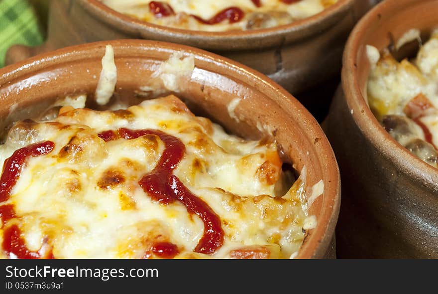 Meat and vegetables with cheese and ketchup  in pots