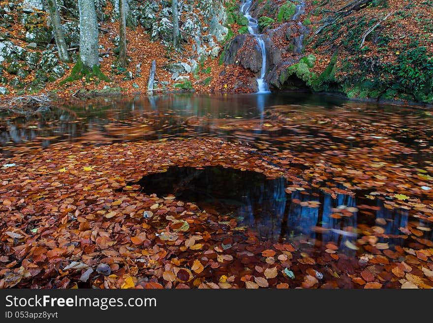 Beautiful autumn foliage, waterfalls and reflection patterns in mountain stream in the forest. Beautiful autumn foliage, waterfalls and reflection patterns in mountain stream in the forest